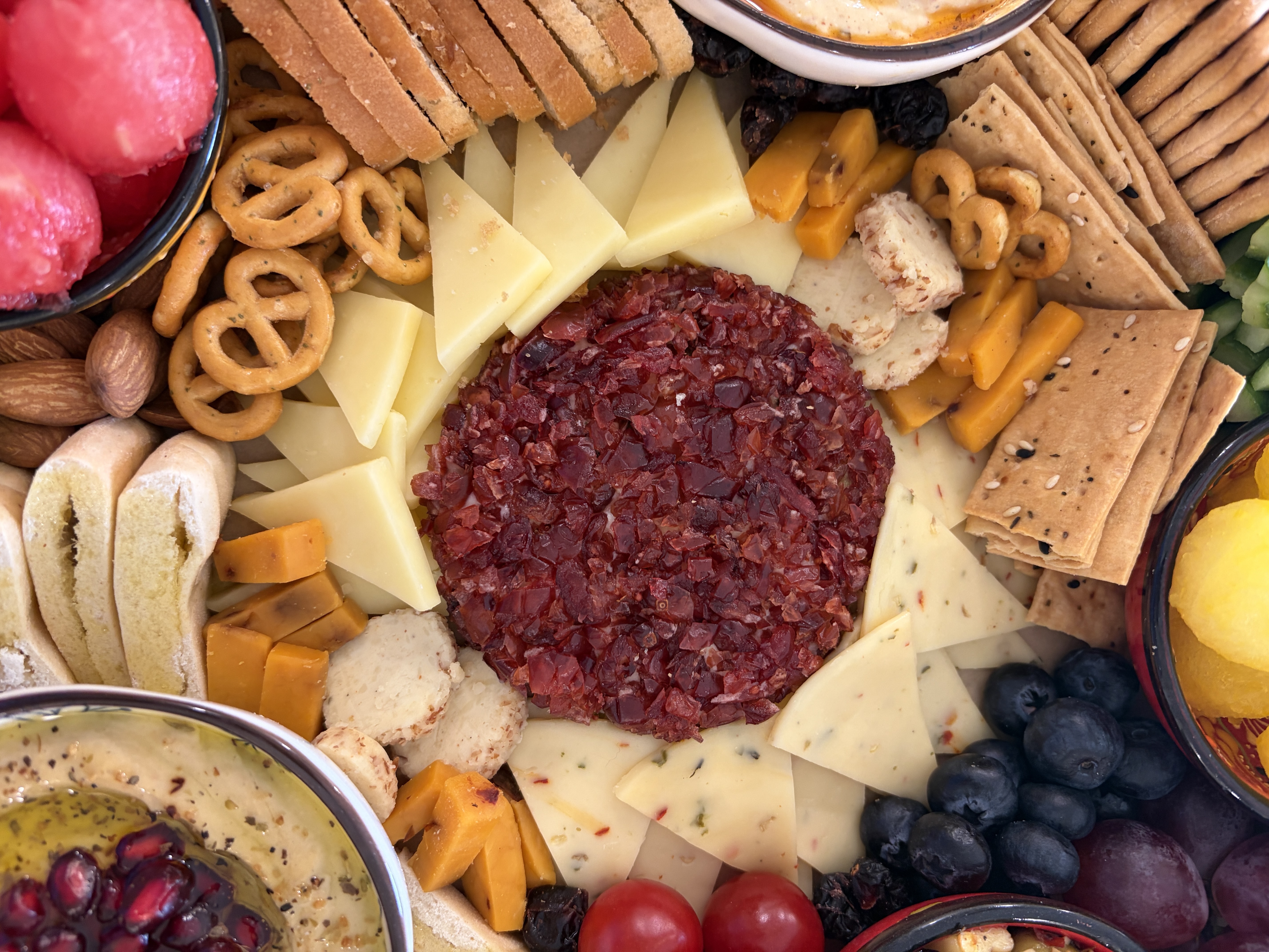 A Gourmet Delights grazing platter with cranberry jalapeño cheese, assorted crackers, fruits, dips, and nuts